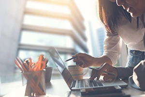 Eine Person zeigt einer anderen etwas auf dem Laptop