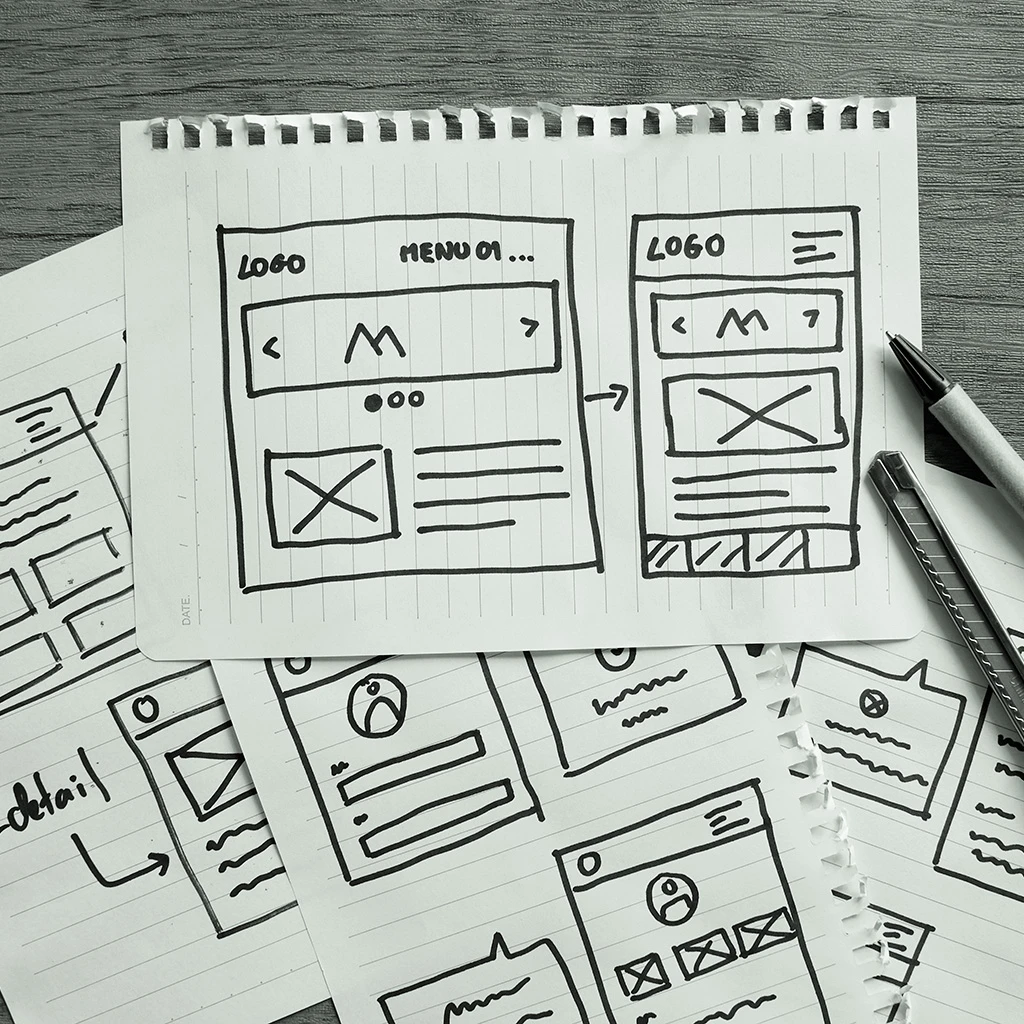 verschiedene Website-Entwürfe (Wireframe) auf Notizzettel skizziert